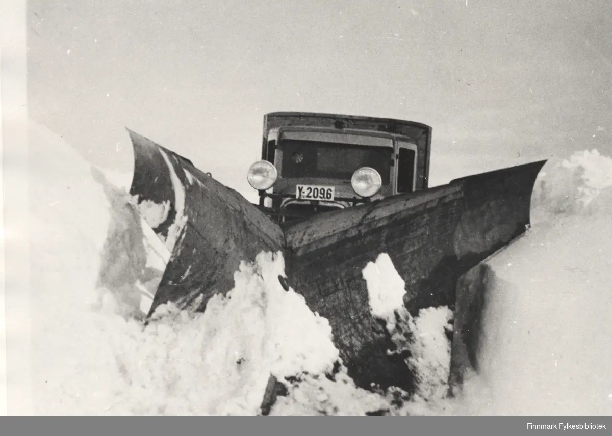 A/S Polarbil brøyter veien, riksvei 950, Nord-Varanger-Vadsø-Varangerbotn i 1940. Y-2096 er en GMC, kfr. Norges Bilbok 1935 (hvor feilskrevet DMC). Årsmodell trolig 1930-1933. Høyt plasserte lykter for brøyting. Se også bildene 577-588.
