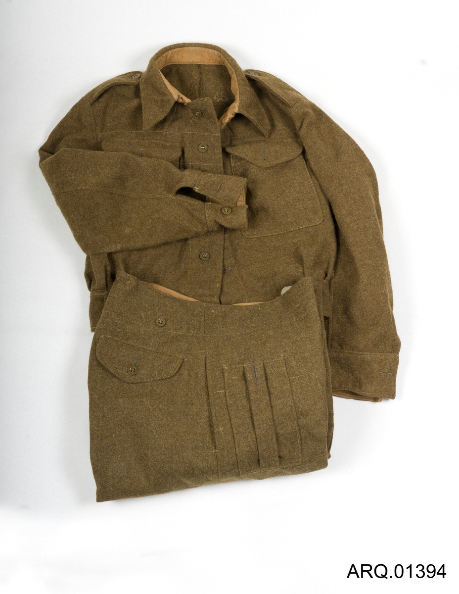 Uniform, Grønn-Brun bestående av ulljakke og ullbukse. Størrelse 48, grønne plastikknapper, jakken har integrert ullbelte rundt linningen. Mulig produsert i england.