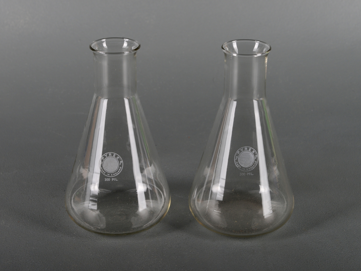 To identiske glasskolber av typen erlenmeyerkolbe. De har en konisk kropp og en sylindrisk hals. Kolbene er laget av borosilikatglass og er av typen "Pyrex". Slike glass tåler høy varme, kjemikalier og temperaturforandringer. De rommer 300 ml.