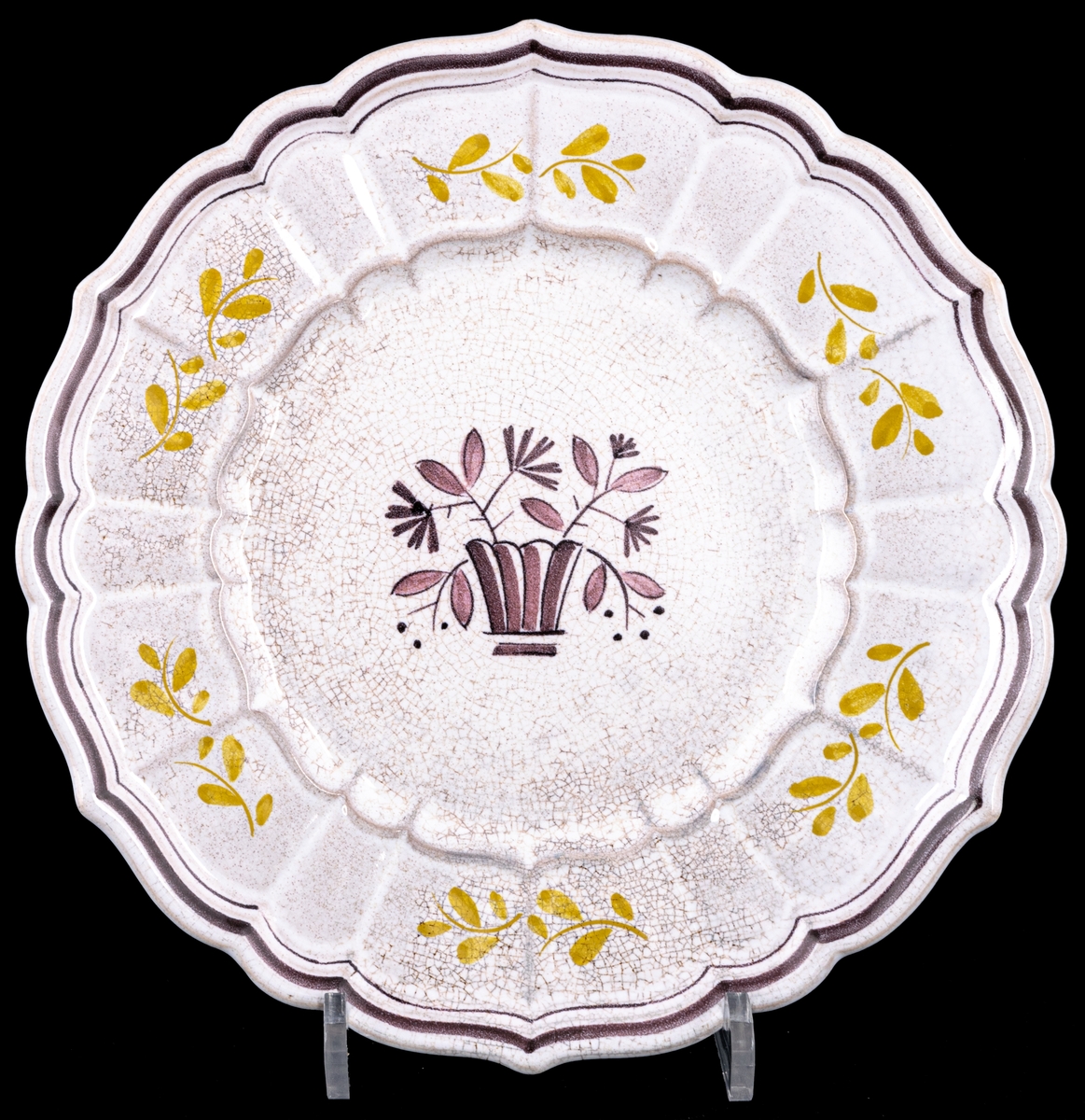 Assiett i flintgods, modell W, handmålad dekor med lila blomkorg i spegeln, gula blomkvistar på brämen samt en lila dubbelrand på brämen.