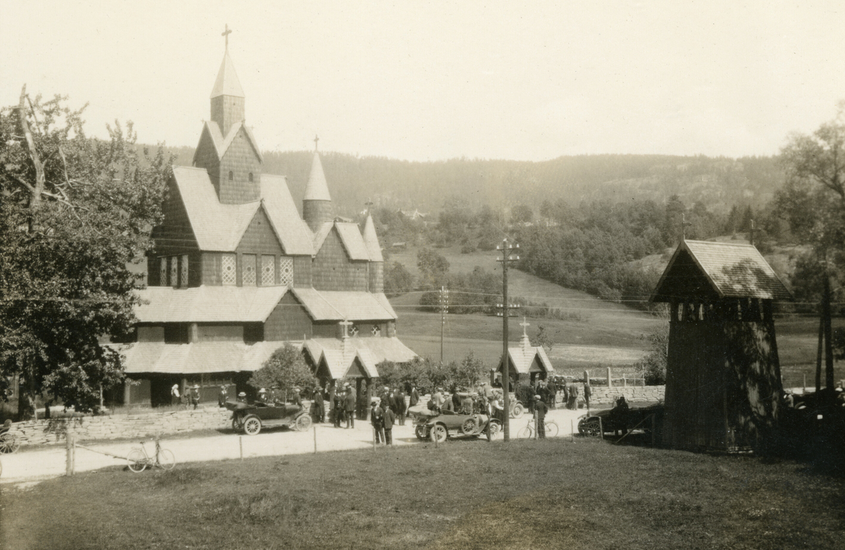 Bilar og folk utanfor Heddal stavkyrkje. Foto frå 20-tallet, ut frå bilane. Ford T 1920-22 til venstre.