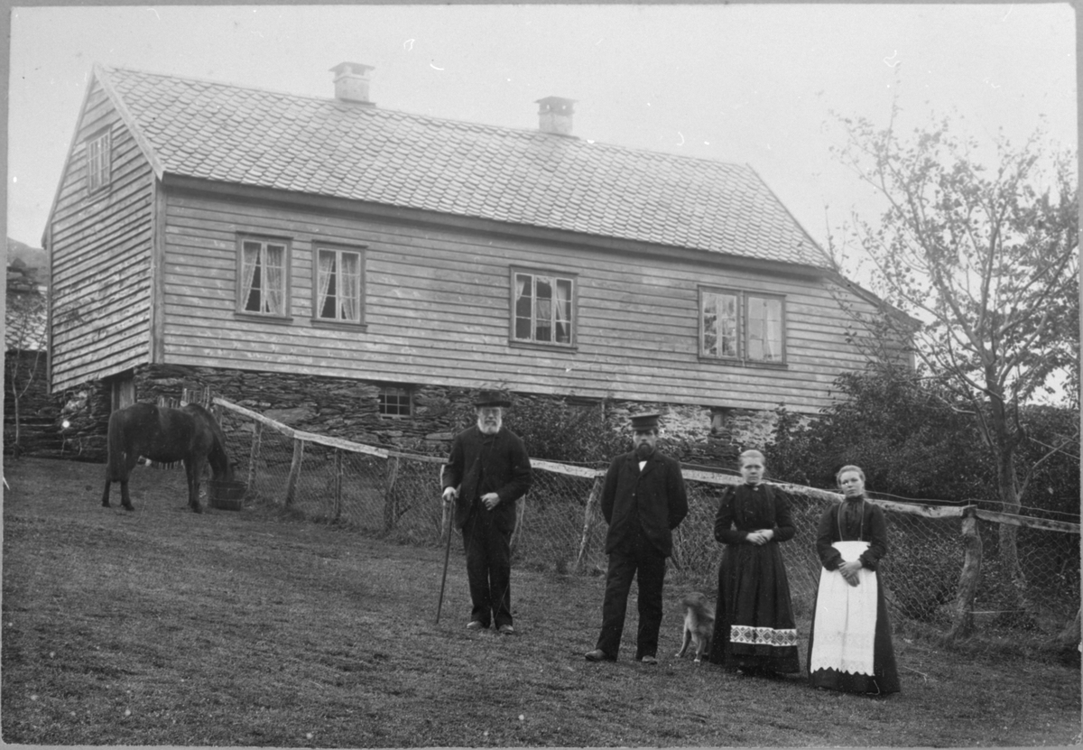 Gardstunet på Heiabø i Ølen, ca. 1909. Frå venstre: Johannes Heggebø d.e., Johannes Heggebø d.y., Marta Heggebø (gift med Johannes d.y.) og Hanna Heggebø (søster til Johannes d.y.).