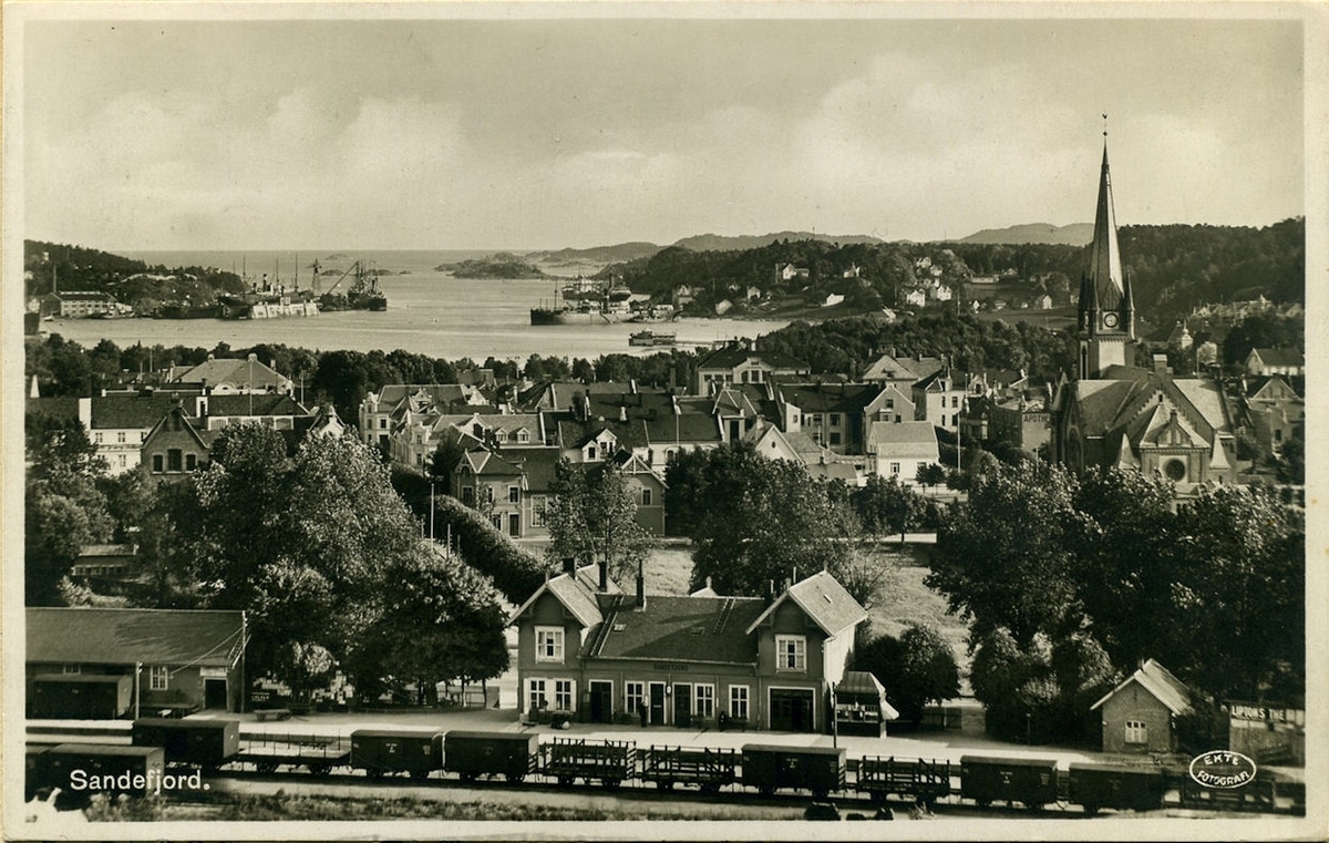 Sandefjord med Sandefjord stasjon i forgrunnen. En rekke godsvogner på stasjonen