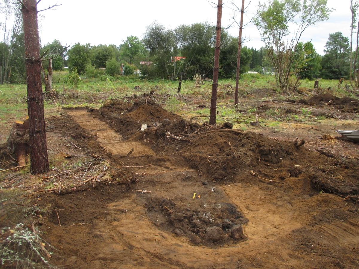 Större härd som påträffades i samband med sökschaktgrävning i det arkeologiska utredningsområdets östra del. Härden har daterats till 200-400-talen e.Kr.