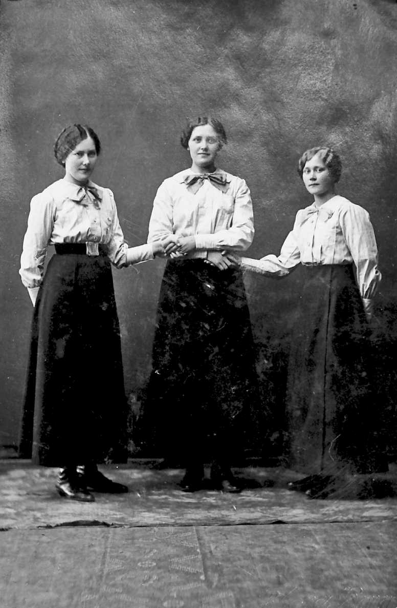 Tre søstre (ANT?) holder hverandre i hendene, portrett. 