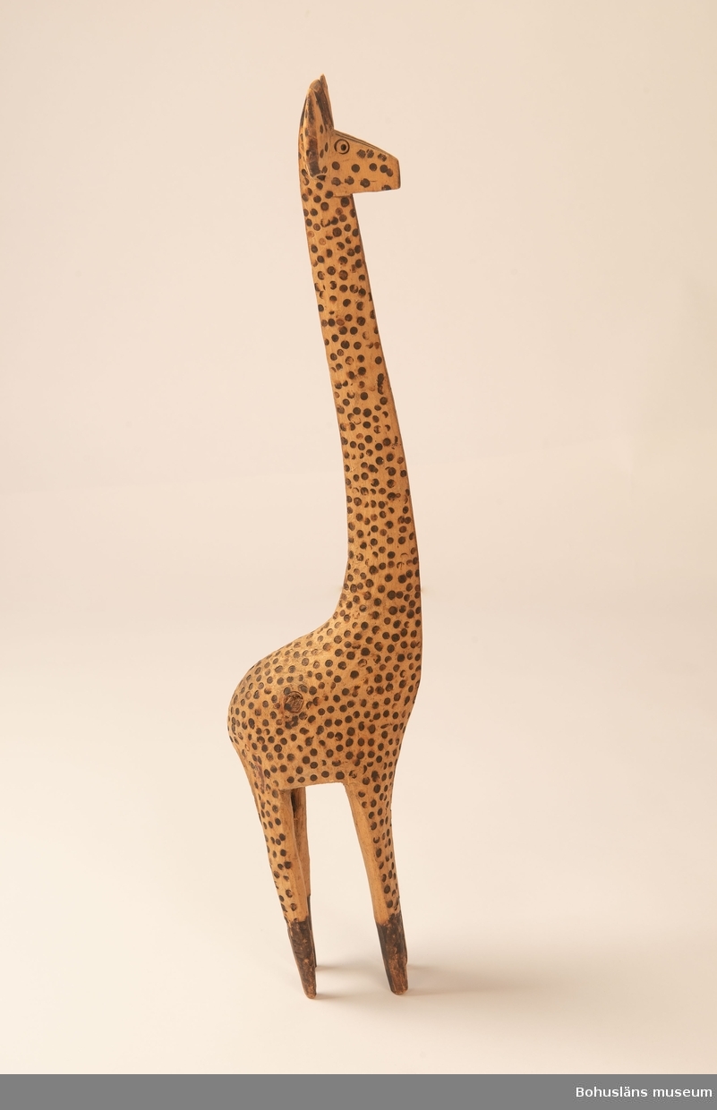 Ur handskrivna katalogen 1957-1958:
Träskulptur; giraff.
H. 69 cm.
de mörka fläckarna istämplade m. ngt. brännjärn. Hel. Infödingsarbete, Sydafrika.

Lappkatalog: 9