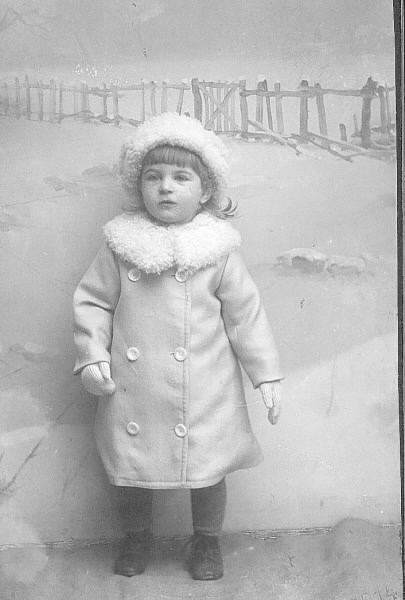 Barnporträtt, ateljéfoto. Barnet bär vinterkläder.