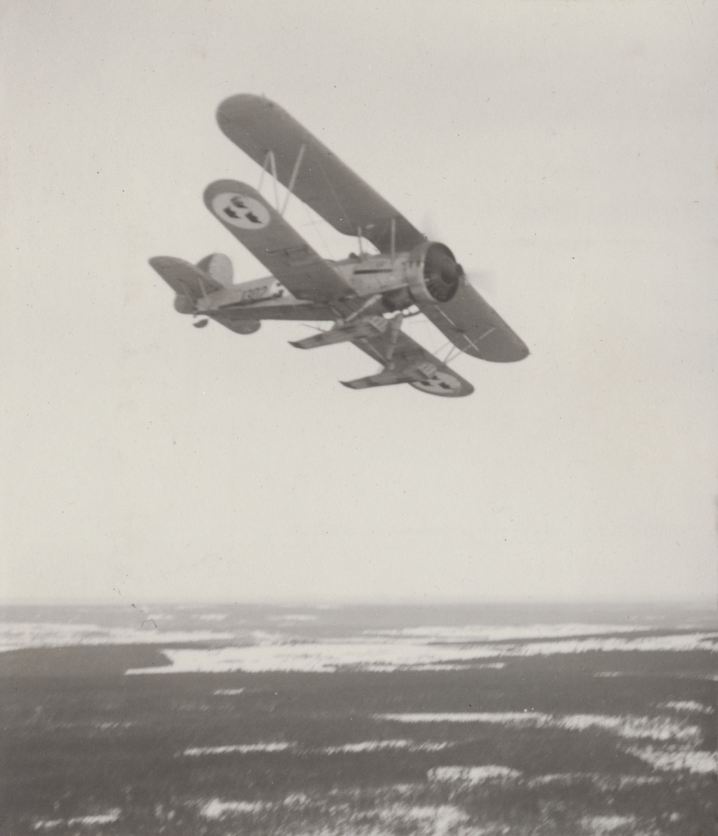 Flygplan B 4 Hawker Hart i luften över snötäckt landskap. Flygbild tagen under svängning.

Text vid foto: "B 4"