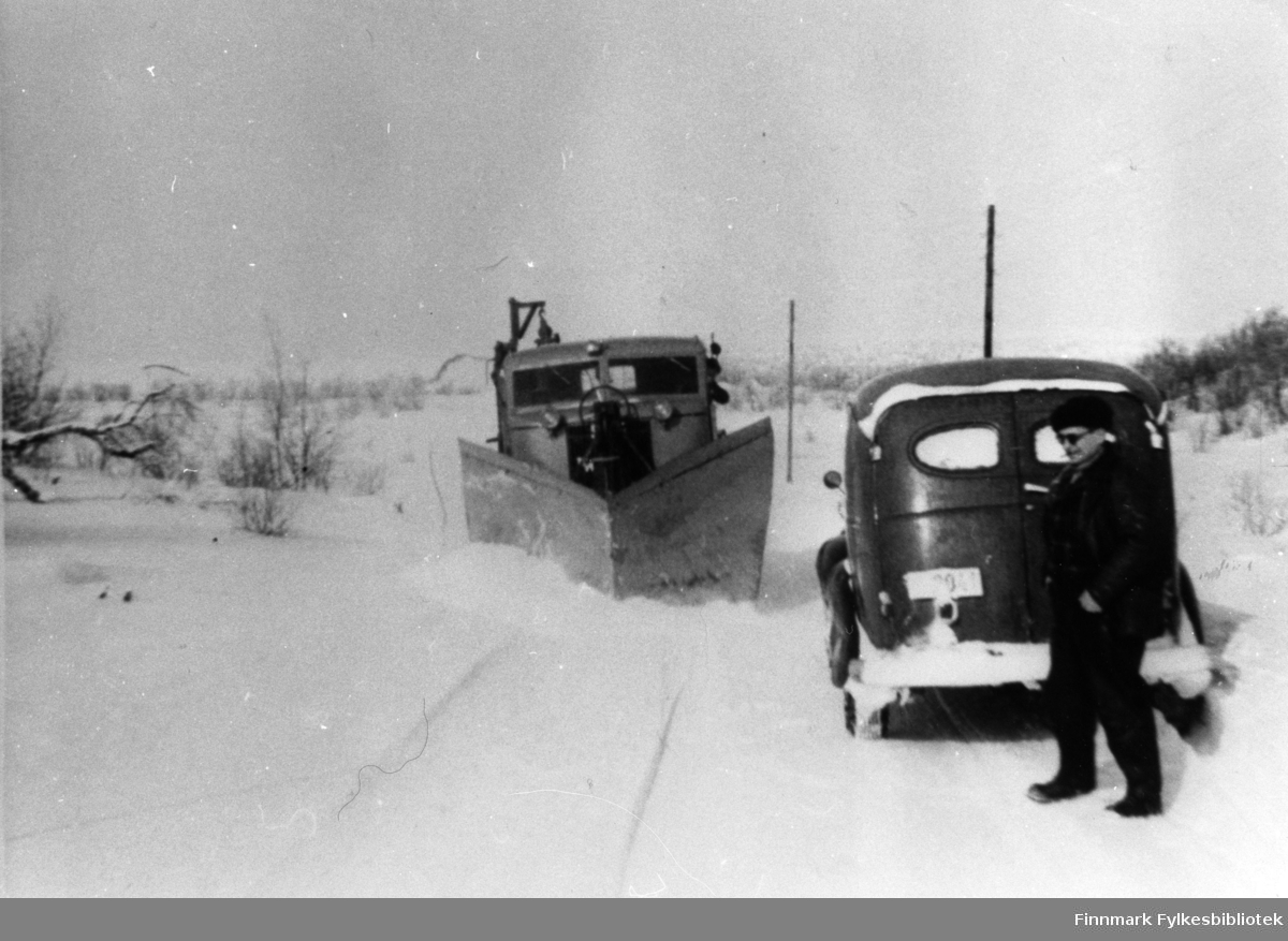 Brøyting. Bildet tatt på landeveien, landskapet ligner på Seidafjellet. Personen på bildet er veioppsynsmann, Kristian Alexandersen, fra Hammerfest. Varebilen ved siden av brøyta er en Chevrolet anno 1946-1947. Brøytebilen er fire-hjulstyrte FWD SU-COE.