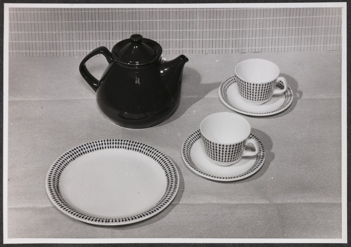 Frokostservise med dekor "Harlekin" fra Stavangerflint A/S. Servisedelene som er avbildet viser en tallerken og to kopper med underskåler, sammen med en tekanne.