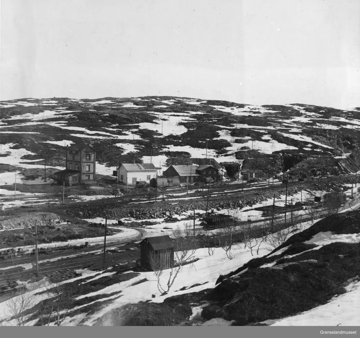 Gruveområde i Bjørnevatn, vi ser transformatorstasjonen, rørbua/badehuset og åpningen til tunnelen der 3000 mennesker oppholdt seg de siste dagene av krigen, 3. mai 1946.