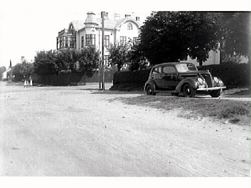 Exteriör av rådman Oskar Mellins villa i hörnet Götagatan-Engelbrektsgatan, kv Oxen 1, Varberg. Bilden tagen mot norr. Utmed gatan står en personbil av märke Ford V8 1937.