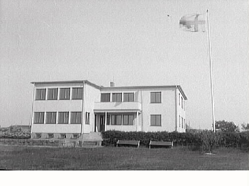 Västerås barnkoloni på Södra Näs, Träslövs socken. Huvudbyggnaden och tomten där en flagga visar på hård vind, sett från norr.