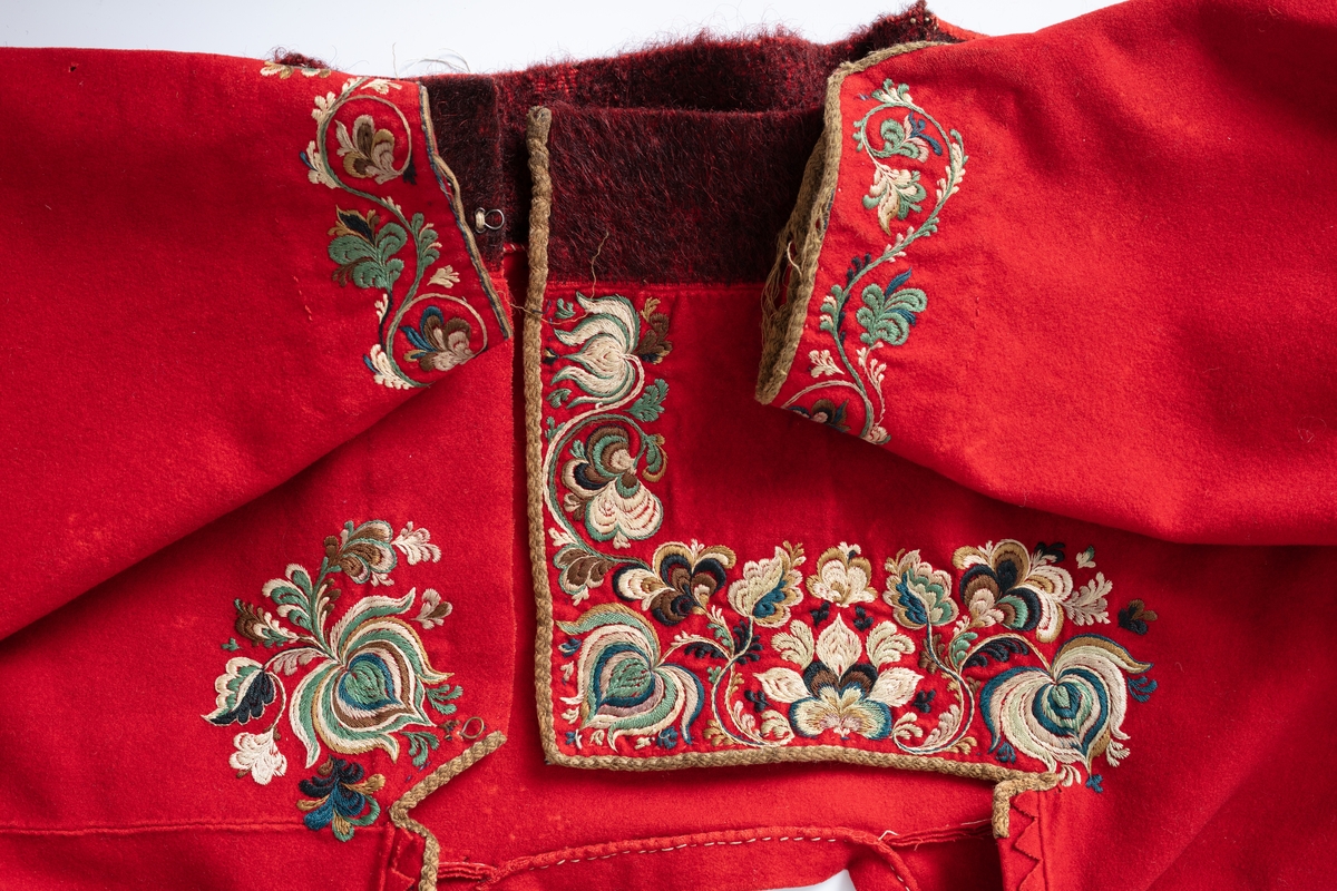 Rød trøye i klede med brodert dekor i silke, mørkrød kant ned.