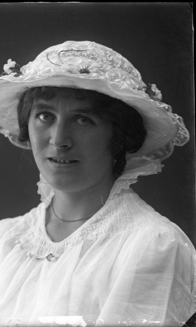 Porträtt av en kvinna med tunn, ljus hatt av spets.