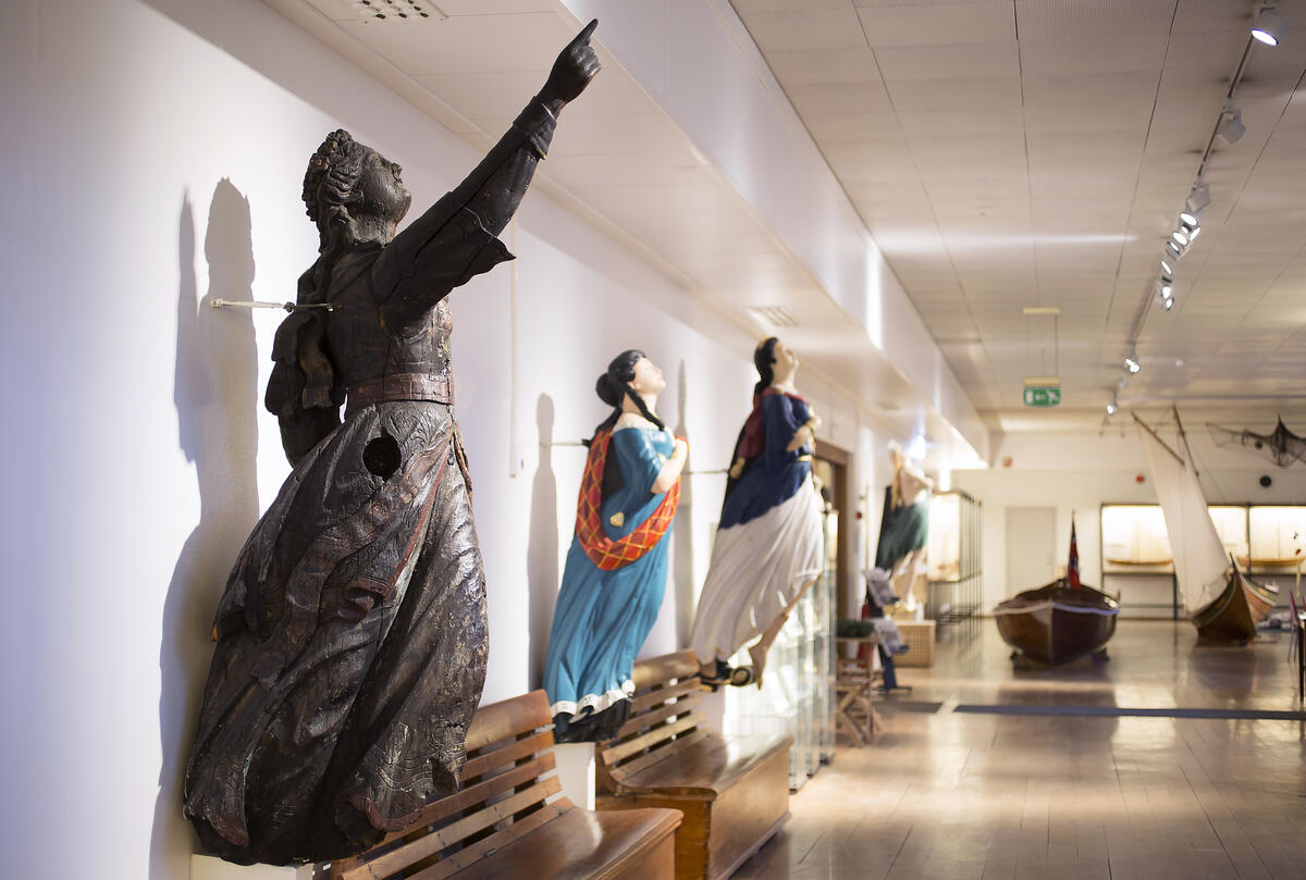fire gallionsfigurer er hengt opp på veggen på museet fra forskjellige tidsperioder
