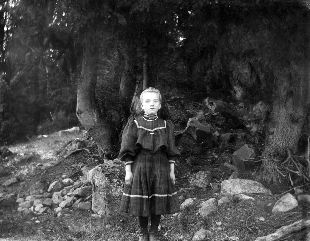 Kjolekledd barn i skogen.