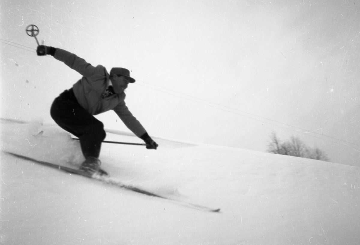 En mann på ski i helfigur. 