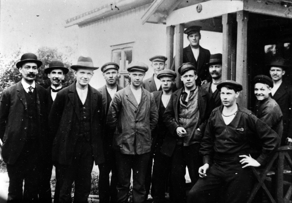 13 män utanför Svenska Verktygsfabriken i Ingelund. Fabriken ägdes av Olsson, Göteborg, som även ägde Elektro-Apparat i Hampens hus på Skepparegatan.