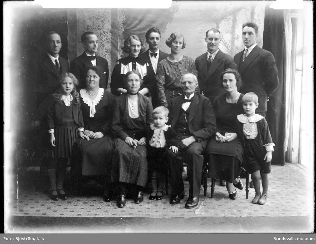 Familjefoto med Nils och Karolina Sjöström, Svartvik, deras fem barn med respektive samt tre barnbarn. Barnen heter Elin, Harry, Gösta, Ingeborg och Fritiof. Längst till vänster barnbarnet Kerstin och den lille i mitten heter Bert.