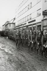 Tyske soldater marsjerer gjennom Torggata 41-43, Hamar. Okku