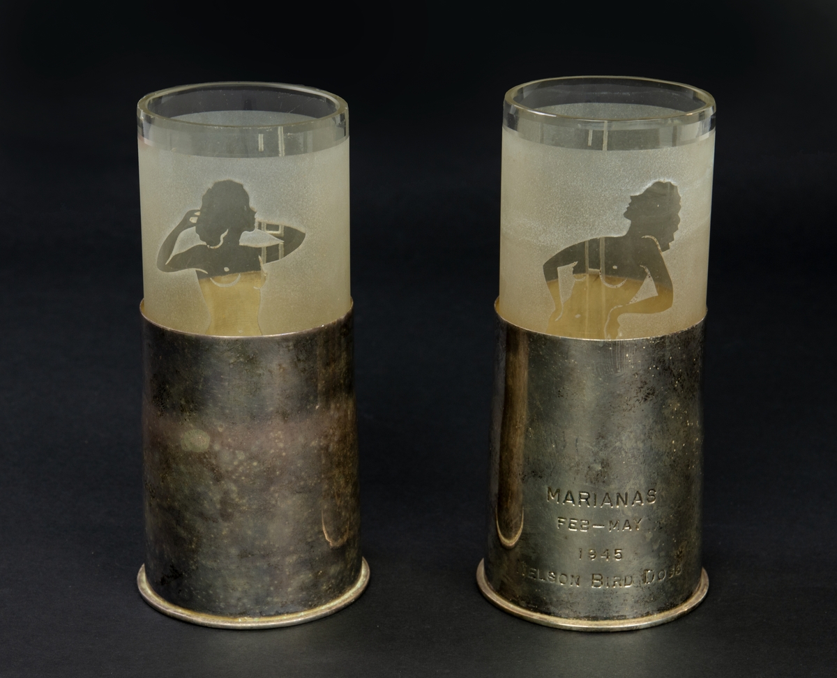 Två stycken behållare i silver med insats av glas. Den ena behållaren har en ngraverad text: "Marianas feb-may 1945 Nelson bird dogs". Glasinsatsen har gravyr med initialerna "EHN" samt en naken kvinna.