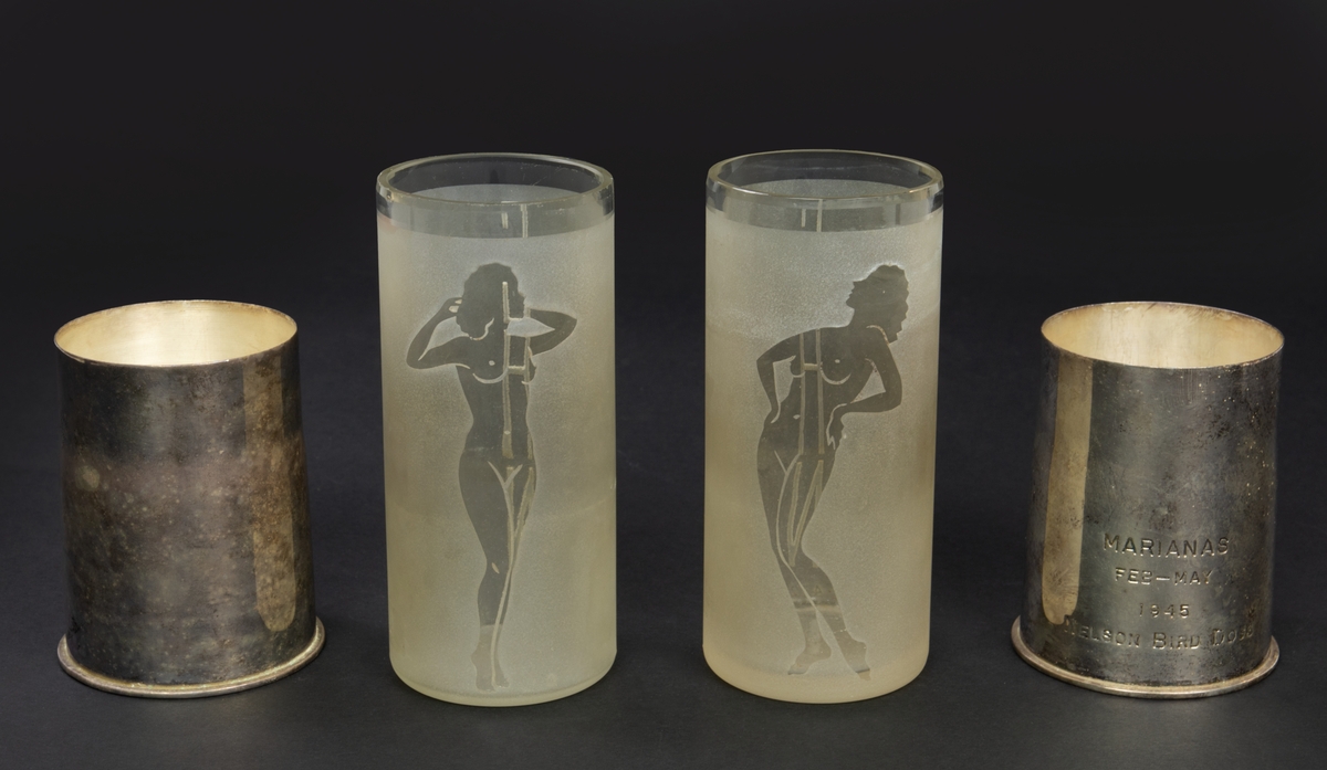 Två stycken behållare i silver med insats av glas. Den ena behållaren har en ngraverad text: "Marianas feb-may 1945 Nelson bird dogs". Glasinsatsen har gravyr med initialerna "EHN" samt en naken kvinna.