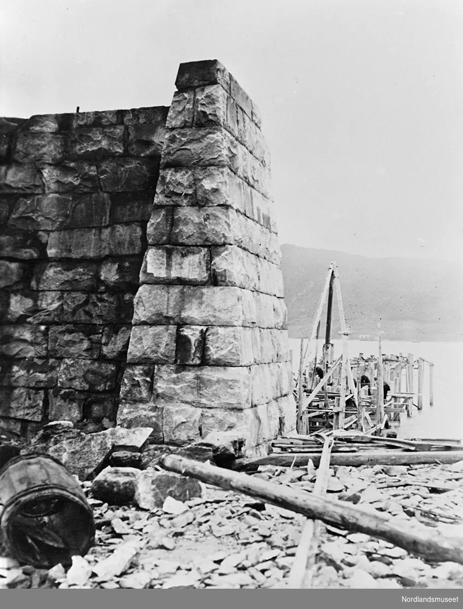 Muring av malmkai 1 i Narvik er påbegynt. En pilar er ferdig. En del materiale vises til høyre og i forgrunnen.