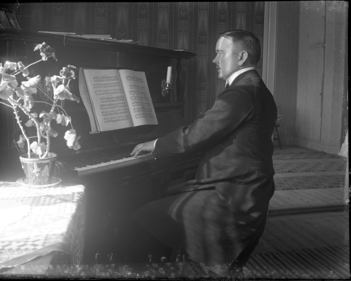 En man sitter vid ett piano och spelar.