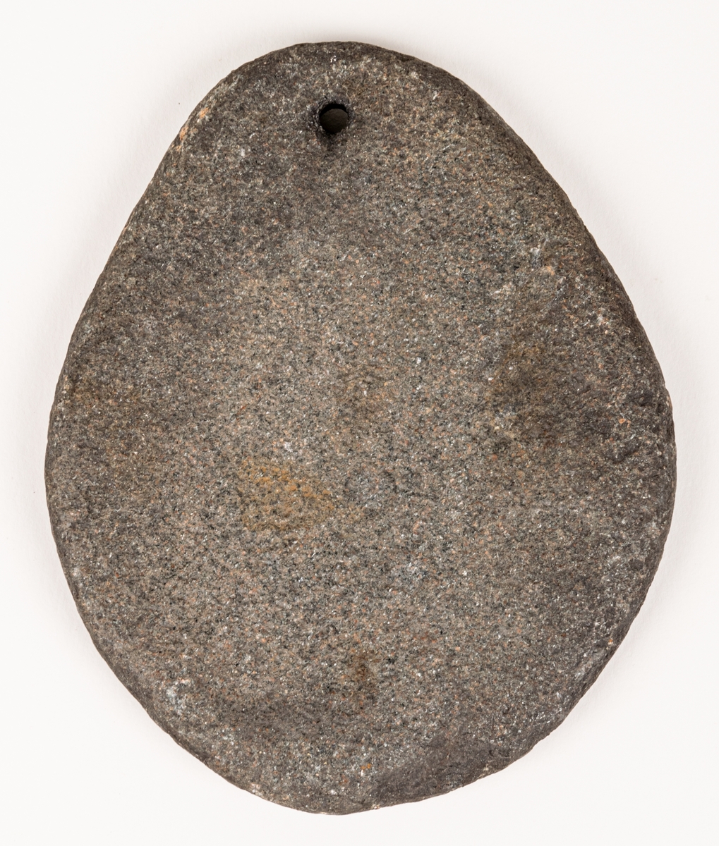 Sten, oval, flat med genomborrat hål nära ena kanten. Möjlighet nätsänke.