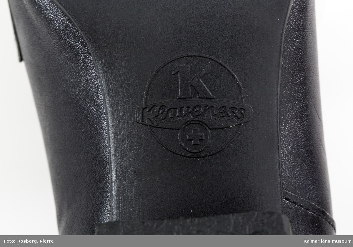 KLM 46140:13. Skor. Ett par svarta läderskor med spänne. På sulan inuti skon tryckt text: GENUINE LEATHER – MADE IN NORWAY Klaveness.