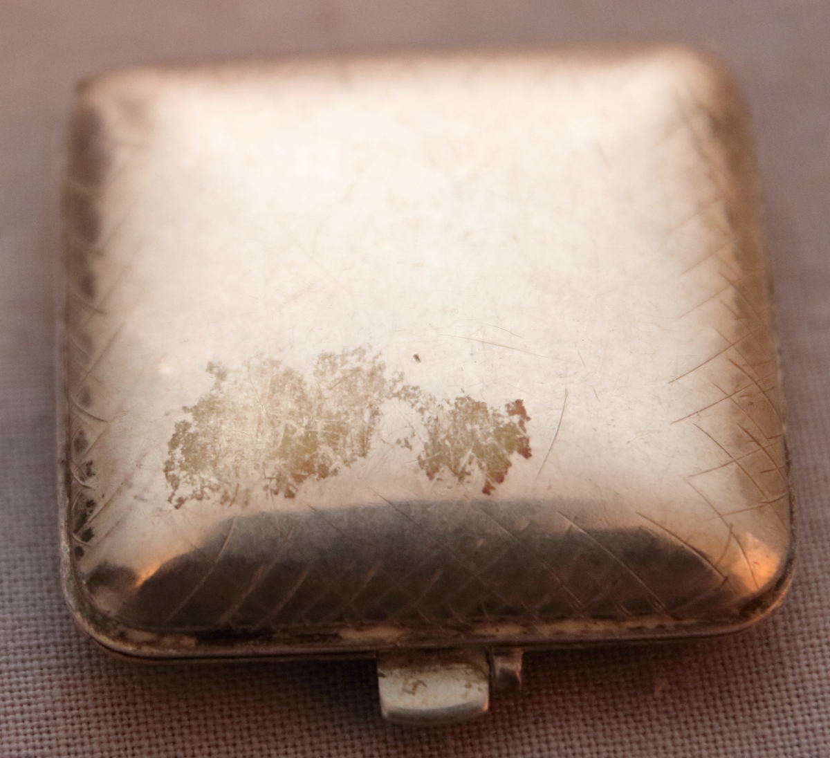 Kvadratiskt fickur med 3,5 cm sida med dubbelsidiga silverboetter, den främre försedd med gångjärn.  Själva uret går att ”fälla ut” så att det står upp i boetterna. Odekorerad förutom dekorativa streck i en bård kring kanterna på boetterna. Stämplarna 925 (sterlingsilver), RG, C5 (1857), en svårtydd stämpel som skulle kunna vara ett lejon ställt på bakbenen med krona på huvudet.