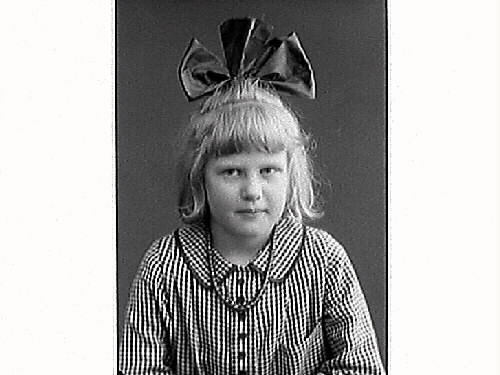 Flickporträtt. Järnhandlare Arvid Ekströms dotter Harriet i smårutig klänning och en stor rosett i håret.