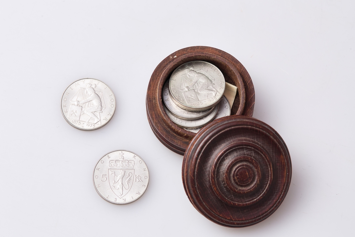 Liten trebeholder. Inneholder 5 kronestykker fra 100års jubeleumet til krone som valuta i 1975.