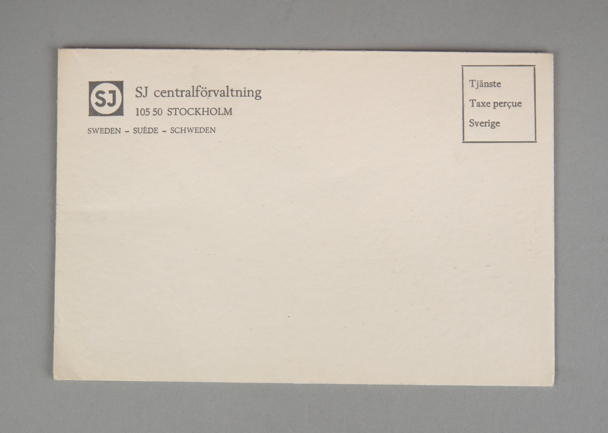 Rektangulärt kuvert av vitt papper. Uppe i vänstra hörnet finns tryckt i grått SJ:s logga och "SJ centralförvaltning 105 50 STOCKHOLM SWEDEN - SUÈDE - SCHWEDEN". Uppe i högra hörnet stämplat i en grå ruta "Tjänste Taxe perçue Sverige".