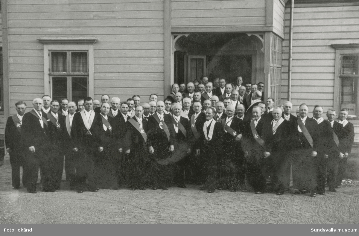 Gruppfoto utanför en större träbyggnad, en stor grupp män, många med ordensband. På bildens baksidan står: Samlingsmötet i Fränsta 10/5 1942. Ur ett album som tillhört Erik Tranberg, Torp.