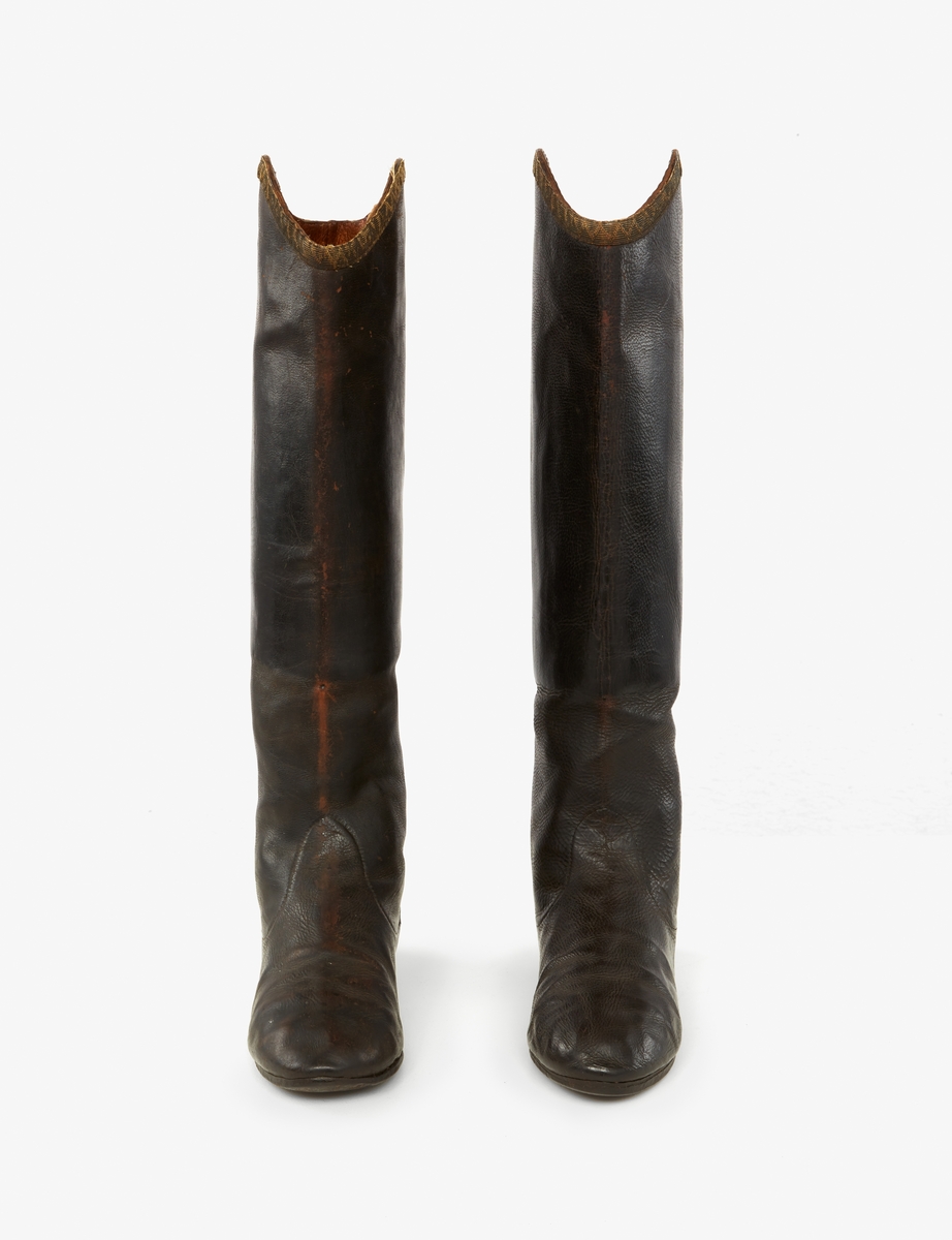 Stövlar tillhörande Gustav III:s daluniform. Av svart läder. Skaftets överkant kantad med band av silvertråd.