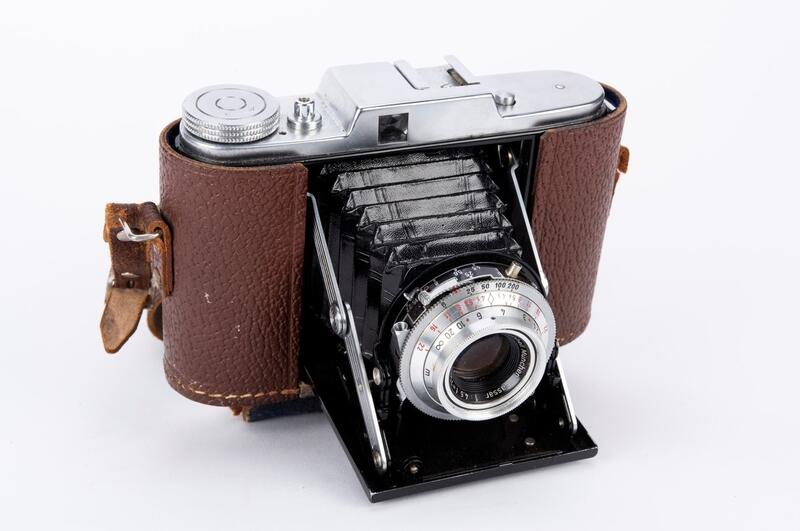 Bildet viser et kamera med detaljer i sort og sølv, beskyttet av et brunt etui av skinn (Foto/Photo)