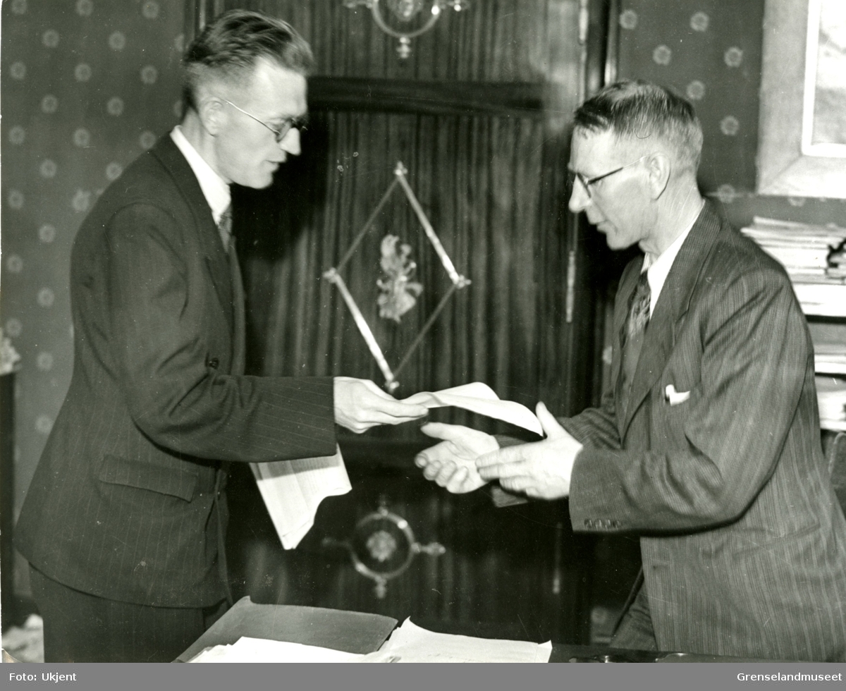 Bildet viser overrekkelse av sjekken på NKR 250.000 fra kirkeneslærerne til kirkeminister Kaare Fostervoll til skolens boksamlinger i Finnmark, 30.05.1946. Dette var startpenger også til Kirkenes bibliotek. Mannen til venstre er Jakob Vaage.  