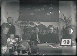 Medlemmer og venner av familien Rydgren i stua i bestyrerbol