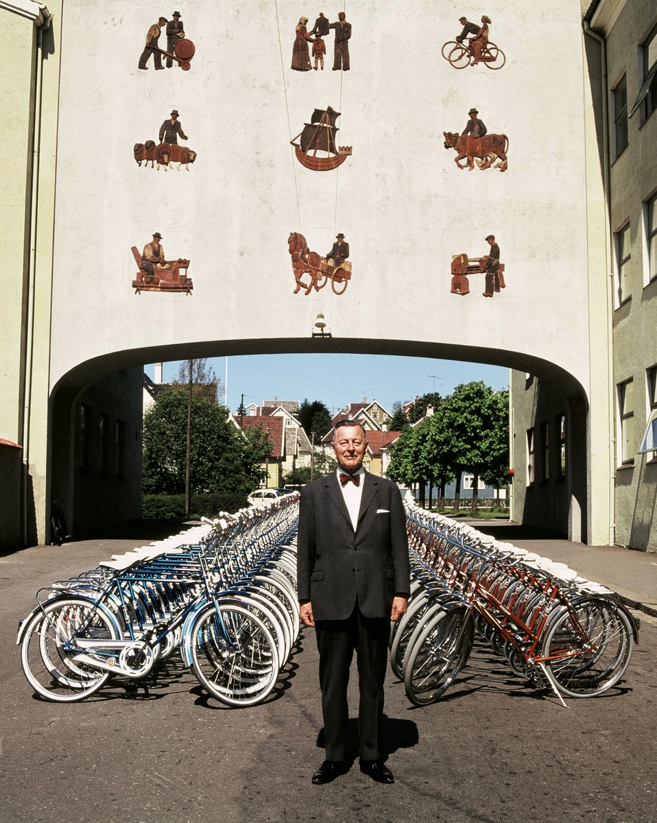 Fotografi av Jonas Øglend foran to rekker sykler fra fabrikken hans.