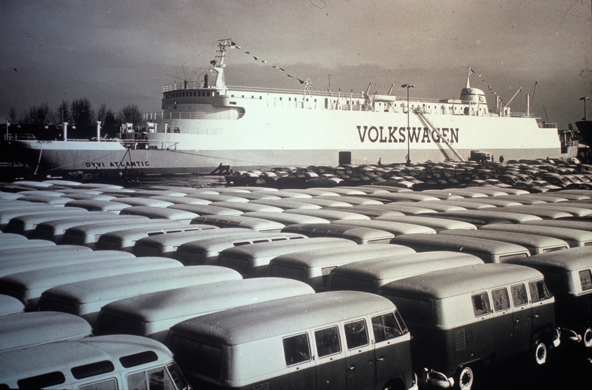 Skipet Dyvi Atlantic med påskrift Volkswagen i havn med store mengder VW busser parkert foran.