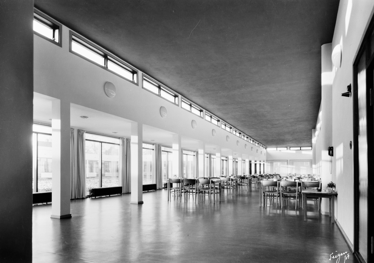 Arkitekturfoto av Økern Aldershjem. Arkitektene Fehn og Grung fikk i 1961 Houens fonds diplom for sin tegning av bygningen. Interiørbilde av hall/spiserom.