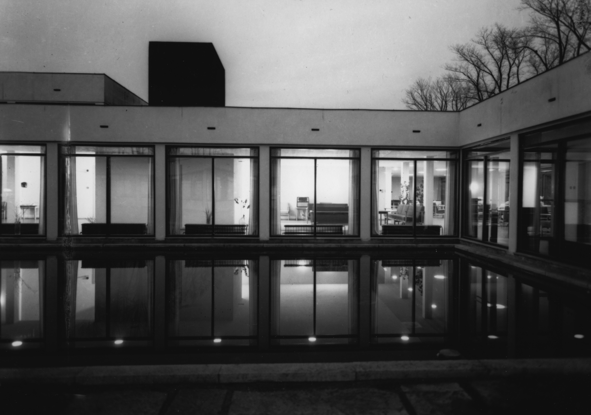 Arkitekturfoto av Økern Aldershjem. Arkitektene Fehn og Grung fikk i 1961 Houens fonds diplom for sin tegning av bygningen. Delbilde av fasadeglass i mørket.