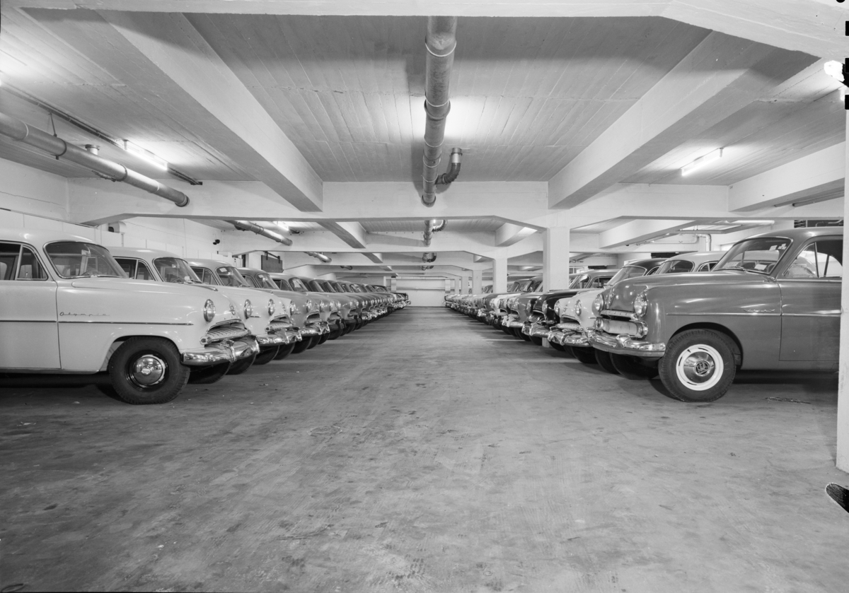 Bilde av en parkeringshall i Gustav Thrane Steens Automobilforretning på Skøyen i Oslo. De forreste bilene er en Opel Olympia og en Vauxhall.