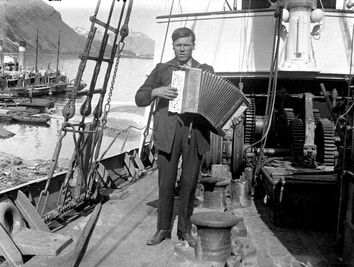 Mann med trekkspill ombord på en hvalfangstbåt. Foto Theodor Andersson (Foto/Photo)