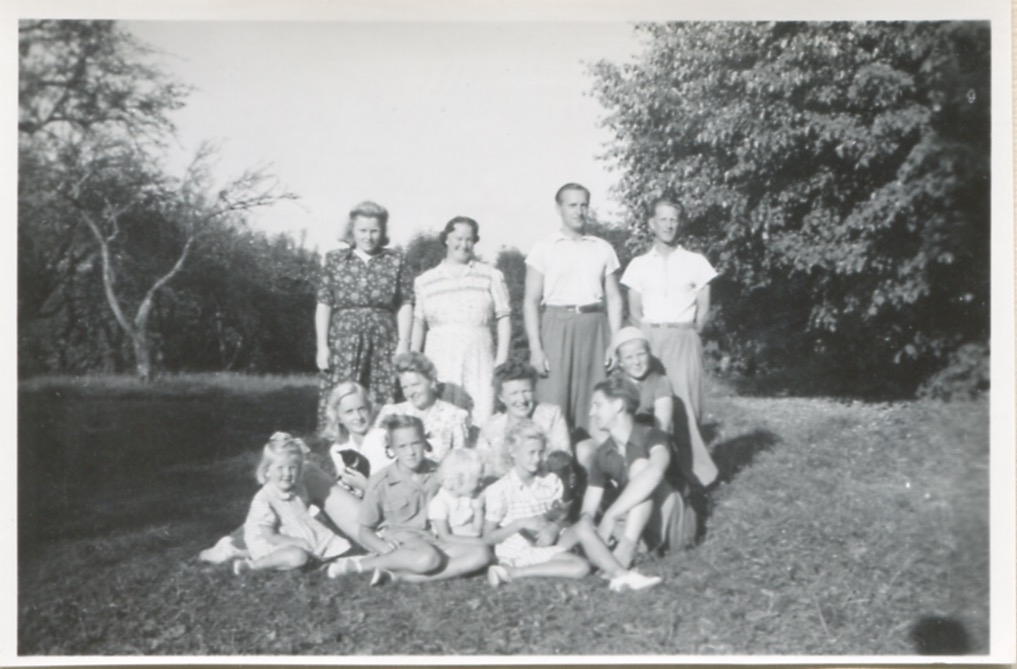 Sommargäster står samlade i "Sandbergs" Sagered 3:3 trädgård cirka 1952.