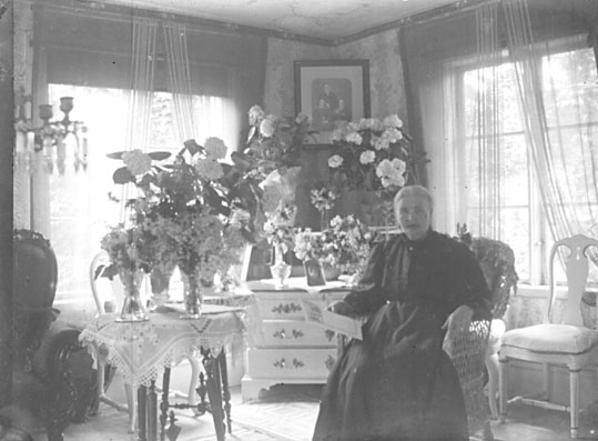 Porträtt, Sara Wretström, med blommor i vaser.