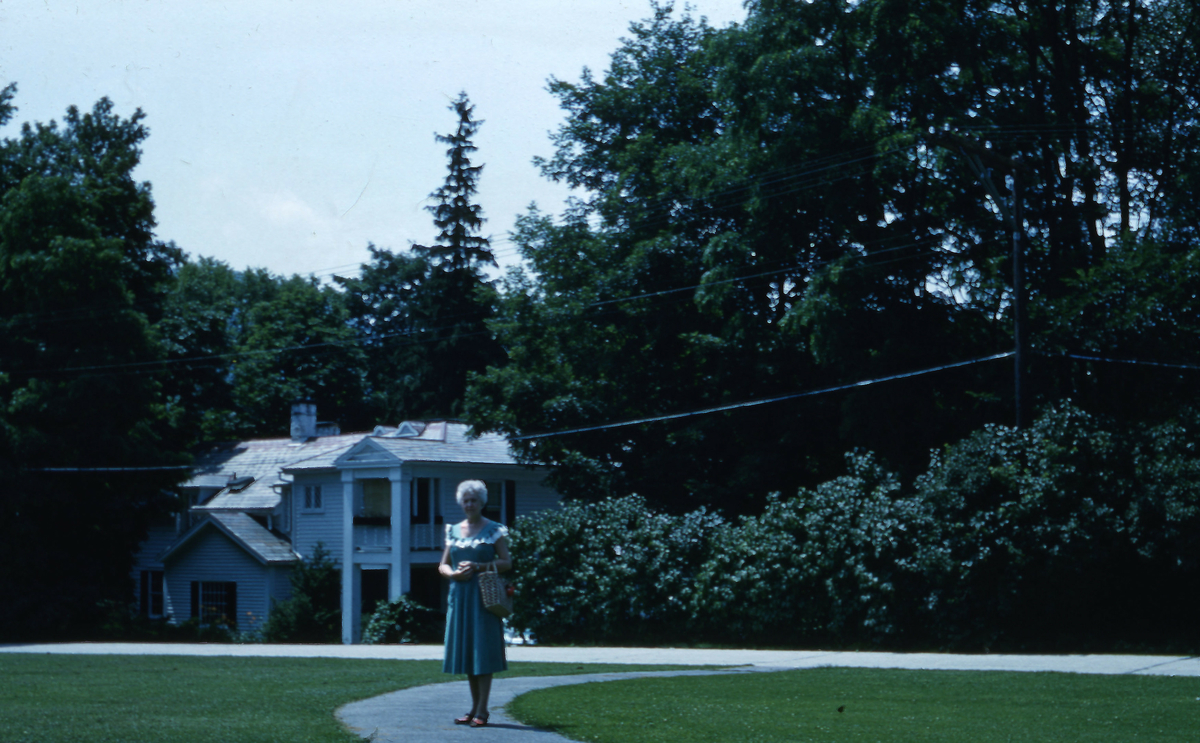 Kvinne foran et "amerikansk" hus