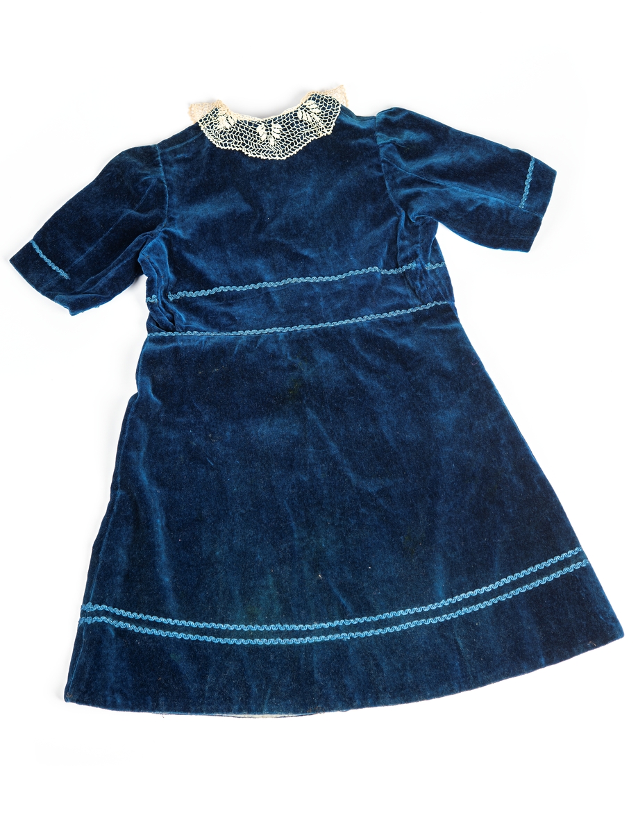 Barnklänning i blå sammet. Togs med på flykt från Lettland till Sverige år 1944. 
